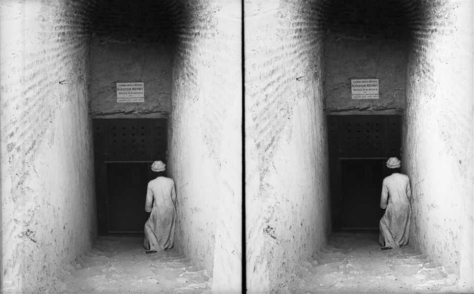 Ingresso della tomba di Nefertari (QV66), con una struttura moderna in mattoni che copre la scala discendente. È visibile una targa commemorativa della scoperta durante gli scavi italiani. Scavi Schiaparelli.