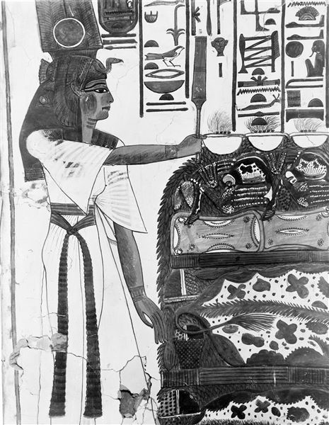 Primo annesso orientale (alcova), parete est, scena 18. La parte sinistra della parete mostra Nefertari con lo scettro Sekhem, davanti a un tavolo colmo di offerte di nell’atto di compiere offerte in onore del dio Osiride, qui non visibile.