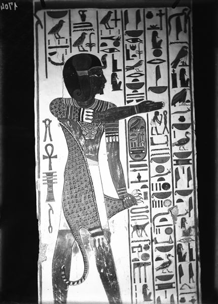 Veduta del pilastro A, lato a, della camera funeraria. Si riconosce il dio/sacerdote Iunmutef, con veste di pelle di leopardo e braccio rivolto verso la parte centrale della camera. L’iscrizione è rivolta a Osiride.