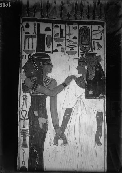 Veduta del pilastro B, lato b, della camera funeraria. Si riconoscono dandosi la mano, la regina Nefertari, a destra, e la dea Iside, a sinistra.