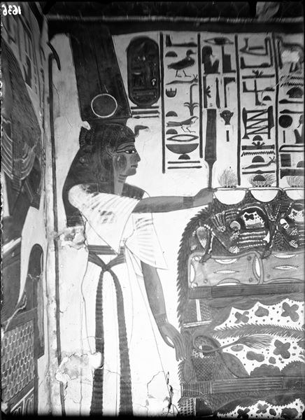 Primo annesso orientale (alcova), parete est, scena 18. La parte sinistra della parete mostra Nefertari con lo scettro Sekhem, davanti a un tavolo colmo di offerte nell’atto di compiere offerte in onore del dio Osiride, qui non visibile.