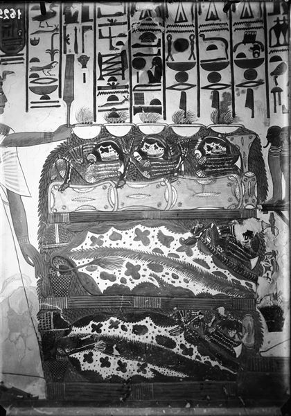 Primo annesso orientale (alcova), parete est, scena 18. Dettaglio del tavolo colmo di offerte rappresentate tra Nefertari e il dio Osiride assiso. L’iscrizione soprastante, da una parte rappresenta l’invocazione di Nefertari con le offerte per il dio, dall’altro la risposta benevola del dio.