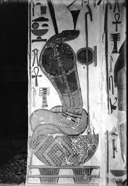 Corridoio discendente, scena 28, lato est dell’accesso alla camera funeraria. È raffigurato un serpente con Doppia corona o Pschent, identificato con Wadjet, che rappresenta il Basso Egitto, su di un cesto a sua volta poggiante su due pilastri Djed. La dea è rivolta verso il corridoio.