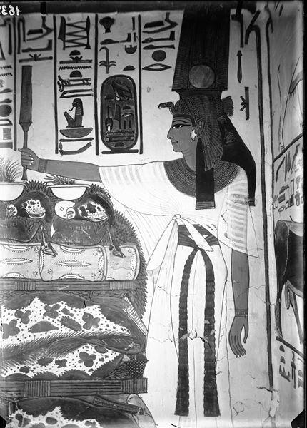 Primo annesso orientale (alcova), parete est, scena 18. Dettaglio della parte destra della parete, dove è presente Nefertari con lo scettro Sekhem, davanti a un tavolo colmo di offerte di nell’atto di compiere offerte in onore del dio Atum, qui non visibile.