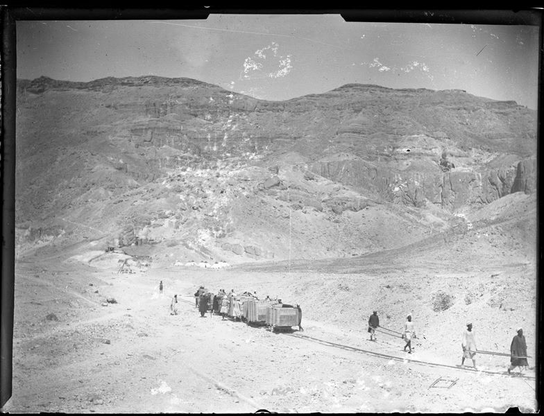Trasporto di casse, contenenti antichità, attraverso rotaie per decauville grazie alla manodopera di operai egiziani, nella Valle delle Regine, presumibilmente nel 1906, quando la missione, pur scavando a Deir el-Medina, aveva ancora il campo base nella Valle, quell’anno con ben nove tende. Scavi Schiaparelli.