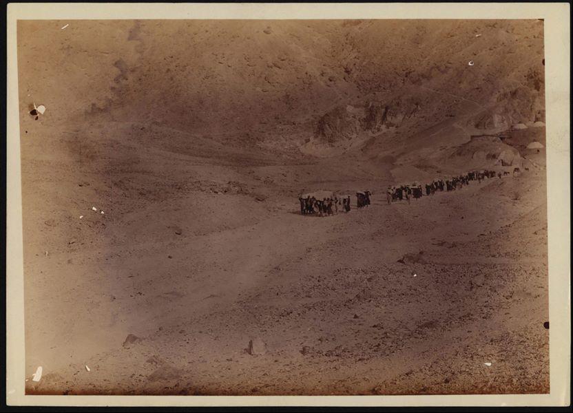 Transporting a number of chests and coffins found during the excavations in the Valley of the Queens, from the Italian Archaeological Mission’s camp (visible in the background on the right) towards the Nile, in Luxor. Schiaparelli excavations.