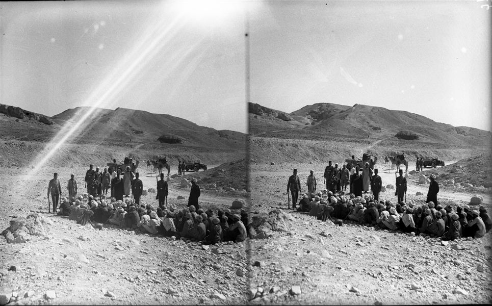 In the foreground, a group of workers and soldiers, with the Museum Director Giulio Farina (in the centre), together with Don Michele Pizzio. In the background, the entrance to the pathway leading to the rock-cut sanctuary of Ptah and Meretseger. Photographed from the Valley of the Queens. Farina excavations.