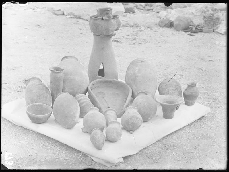 Different types of clay artefacts, found scattered in different contexts. Among them are: an offering table, in the centre (S.14259); a multi-vase structure on a stand (S.14225); globular vases (S.14235,3,47); a cylindrical vase (S.14236) and a bowl (S.14250). Schiaparelli excavations. 