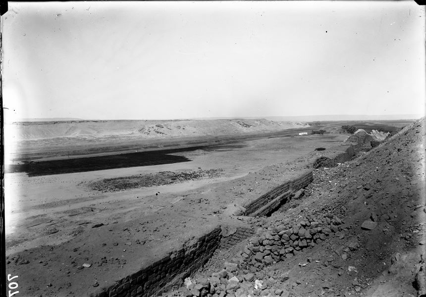 Southern hill, western side. The impressive mud-brick structures and buttresses at the foot of the fortress, before excavations began. In the background, part of the northern hill. Schiaparelli excavations. 