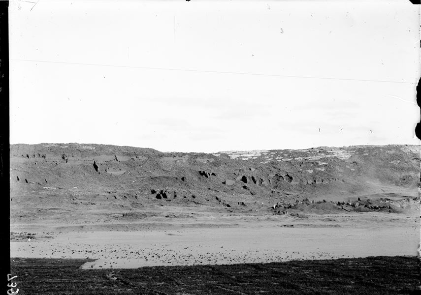 General view of the western side of the southern hill. The workers engaged in the excavation at the bottom of the valley are visible. In the background, are the impressive mud-brick retaining structures. Schiaparelli excavations. 