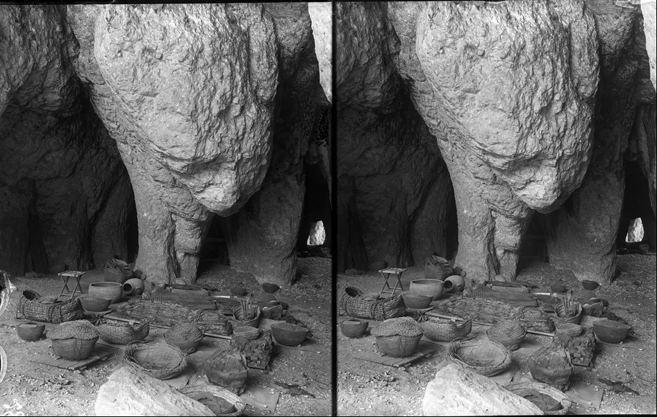 Inside the large natural caves used for the study and packaging of the excavated materials. The more delicate and perishable finds were placed on wooden platforms to facilitate their transport and packaging. Schiaparelli excavations. 