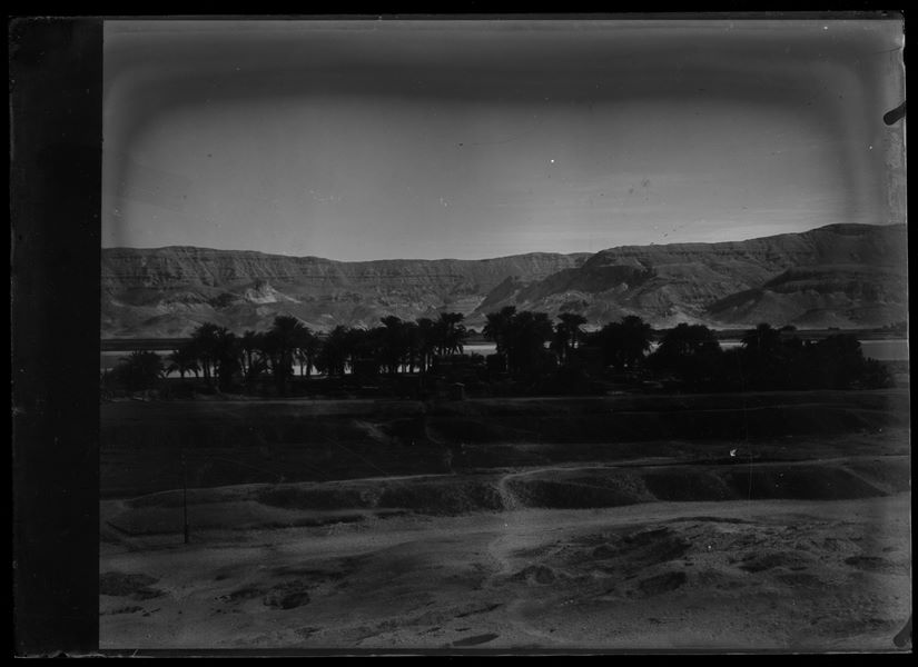 View of the plain overlooking the Nile. Holes from previous excavations are visible. In the background, the narrow gauge railway for the transport of sugar cane. Schiaparelli excavations.