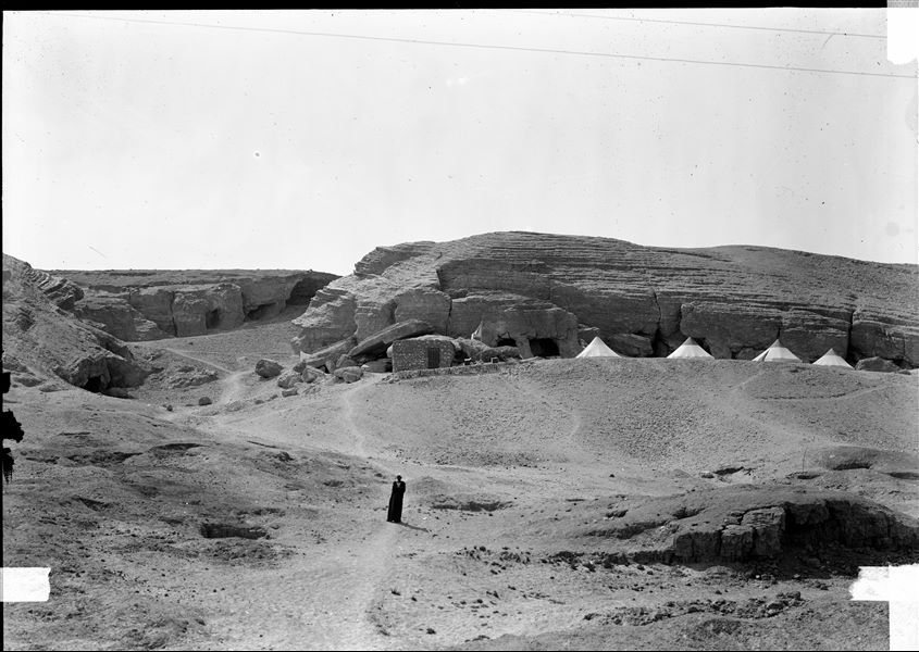 Camp of the Archaeological Mission, set up on a southern plateau of the first hill. The conical tents were lent to the Mission by the Royal Italian Army. In the background, the openings of a series of rock-cut tombs can be seen, later converted into stone quarries. Schiaparelli excavations. 