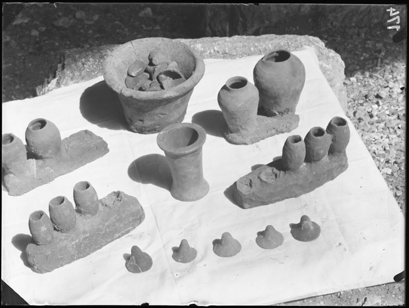 Tomb of the Unknown. Before being packed for transport, the objects were inventoried and photographed, often grouped together. Visible in the picture: four series’ of miniature clay vases with lids (S. 14003,4,8,29); a vase containing clay lids (S.13960); and an alabaster ointment jar (S.14038). Schiaparelli excavations. 