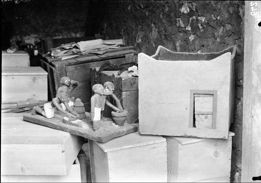 Tomb of Ini. Before being packed for transport, the objects were inventoried and photographed, often gathered in groups. The picture shows the preparation of packing special crates to house the materials. Visible in the foreground: a model of a granary (S.13270) and a model showing domestic activities (S.13271). Schiaparelli excavations.