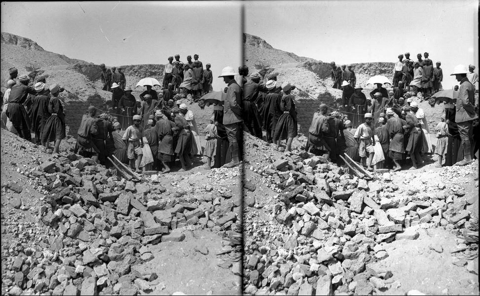 Northern Necropolis. Excavating on the upper part of the hill. Ernesto Schiaparelli can be identified in this photograph. He is in the centre under a white parasol, around him are three clergymen from the Franciscan Mission of Luxor. The person on the right wearing a pith helmet (colonial style helmet) is not identifiable. Schiaparelli excavations. 