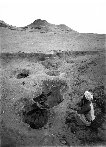 Northern necropolis. Burial pits, the remains of the mats which the dead were wrapped in are still visible. In the central pit, a terracotta boat or granary model can be seen. Farina excavations. 