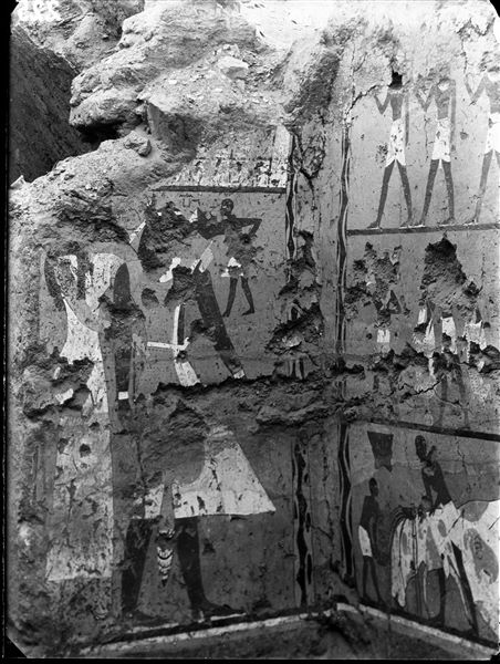Tomb of Iti and Neferu. The image shows the corner between the back wall and the right side-wall. The deceased couple is depicted on the left, and the right side-wall displays offering scenes of livestock and a ritual slaughter. Schiaparelli excavations. 