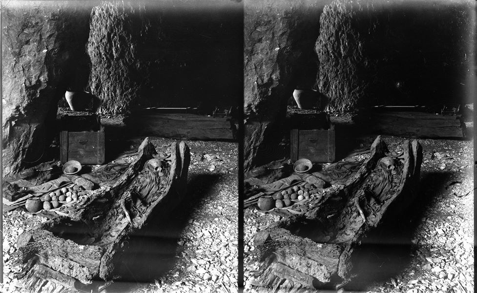 Interno dei grottoni naturali. Notevole quantità di materiale funerario. Al centro una deposizione in tronco. Il fusto dell’albero, trasformato in sarcofago, veniva bloccato sulle testate da tavole di riporto. Scavi Schiaparelli. 