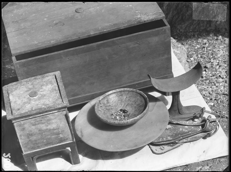 Tomb of the Unknown. Before being packed for transport, the objects were inventoried and photographed, often grouped together. Visible in the picture: two chests with lids (S.13986 [the larger one] and S.13985); an alabaster dish (S.14040); a stone bowl (S.14039); a wooden headrest (S.14041) and a pair of leather sandals (S.14043). Schiaparelli excavations.  
