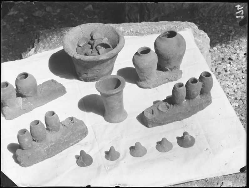 Tomb of the Unknown. Before being packed for transport, the objects were inventoried and photographed, often grouped together. Visible in the picture: four series’ of miniature clay vases with lids (S.14003,4,8,29); a vase containing clay lids (S.13960); and an alabaster ointment jar (S.14038). Schiaparelli excavations. 