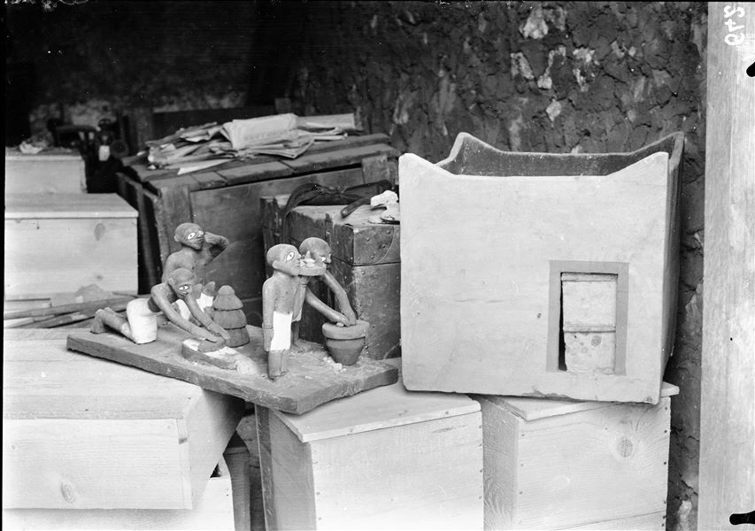 Tomb of Ini. Before being packed for transport, the objects were inventoried and photographed, often gathered in groups. The picture shows the preparation of packing special crates to house the materials. Visible in the foreground: a model of a granary (S.13270) and a model showing domestic activities (S.13271). Schiaparelli excavations. 