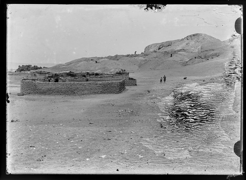  Modern enclosure at Gebelein with some Egyptians walking. Behind this, on the hill, excavations by the Italian Archaeological Mission were taking place. Presumably Schiaparelli excavations.