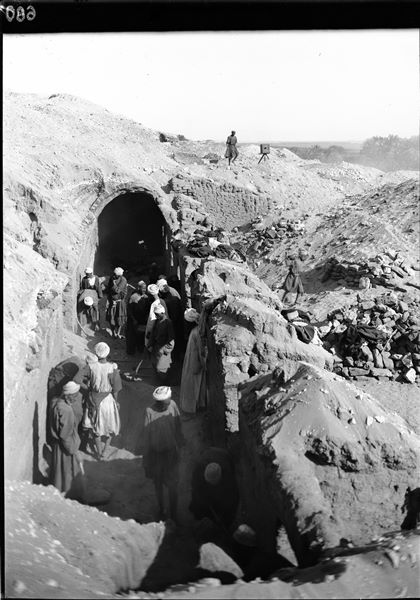Tomba in mattoni crudi con porticato. Operazioni di sterro della parte terminale del porticato. E’ ben visibile il muro di contenimento del cortile digradante verso valle e la seconda macchina fotografica in dotazione alla missione. Scavi Schiaparelli.