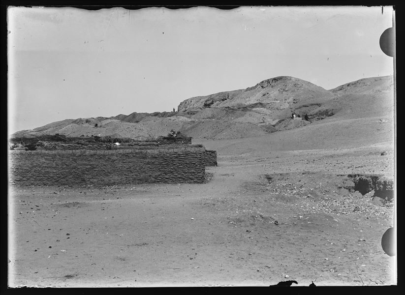 Muretto di una fattoria moderna nelle campagne presso di Gebelein. Sullo sfondo sono visibili gli scavi della missione, e l’uomo con il parasole potrebbe essere Schiaparelli, essendo lui solito portarlo con sé. Scavi Schiaparelli. 