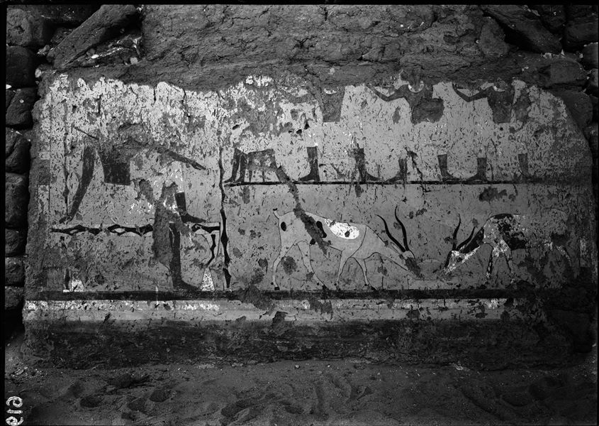 Tomb of Iti and Neferu. This scene depicts the deceased Iti seated on a stool lined with cowhide in the shade of a pavilion, watching two tame antelopes feeding. Above are four male figures, one is shown seated, while the others are shown standing and drawn from a frontal view. Schiaparelli excavations.
