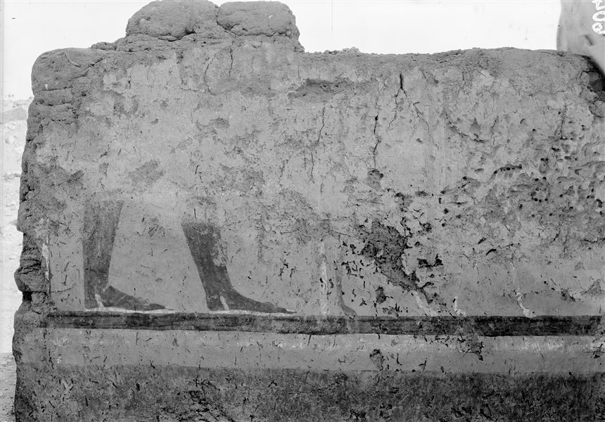 Tomb of Iti and Neferu. Pillar number 7. In this painting the deceased is depicted standing and holding his long staff, together with one of his dogs. He is wearing elegant sandals with wooden soles and laces between his toes, made of vegetable fibre or leather. Schiaparelli excavations.