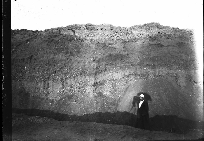 View of the upper part of the south hill, with the extremely large wall that bordered the fortress to the west. The shadow cast is that of the photographer under a parasol. Schiaparelli excavations. 