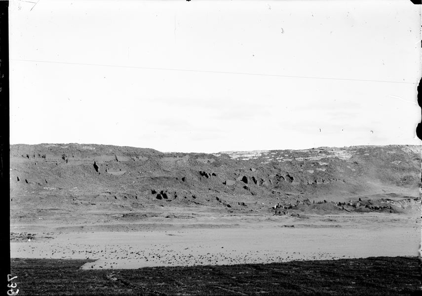 General view of the western side of the southern hill. The workers engaged in the excavation at the bottom of the valley are visible. In the background, are the impressive mud-brick retaining structures. Schiaparelli excavations. 