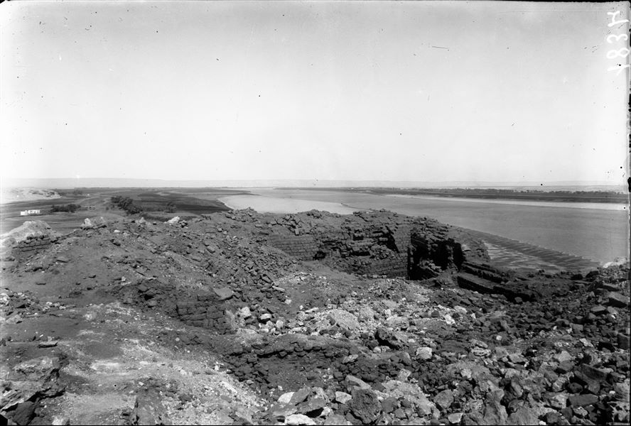Summit of the southern hill, among the remains of the fortress, which are mixed with the remains of a temple dedicated to the goddess Hathor. This is a particular image as it provides a general view of the site: on the left is the northernmost extension of the northern hill, while on the right is the river that runs alongside the southern hill. Schiaparelli excavations. 