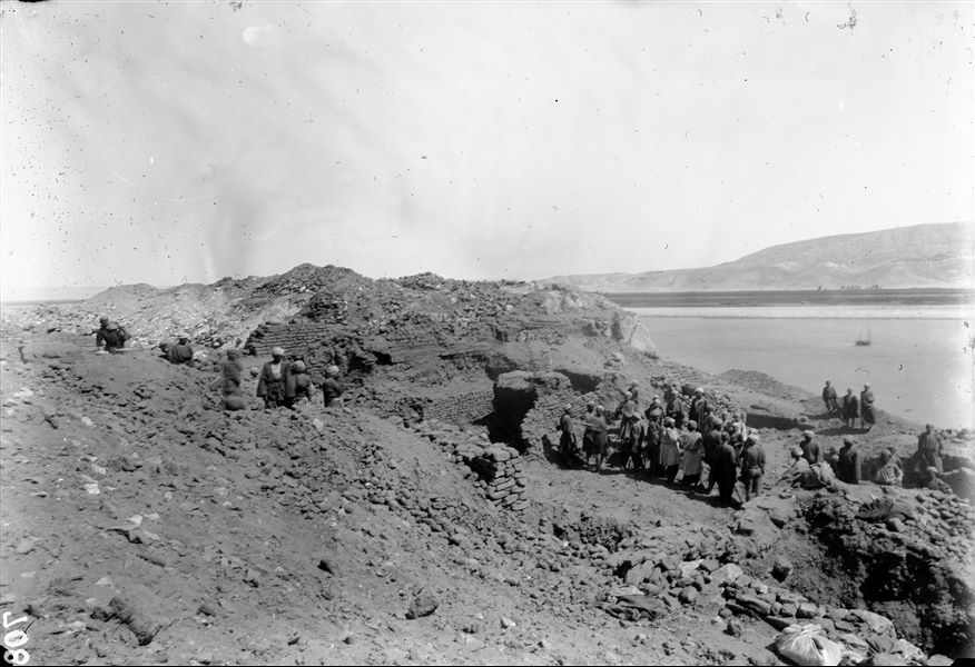 Summit of the southern hill. Excavations among the remains of the temple dedicated to the goddess Hathor and those of the nearby fortress. On the right, the Nile and the Eastern Desert mountain range. Schiaparelli excavations. 