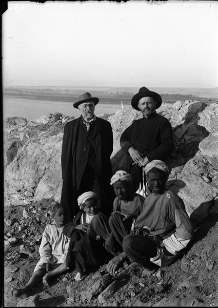 Top of the south hill. Two figures, probably relatives of Ernesto Schiaparelli and the chaperones of his nieces Bianca and Rina, are shown with some workers. Schiaparelli excavations. 