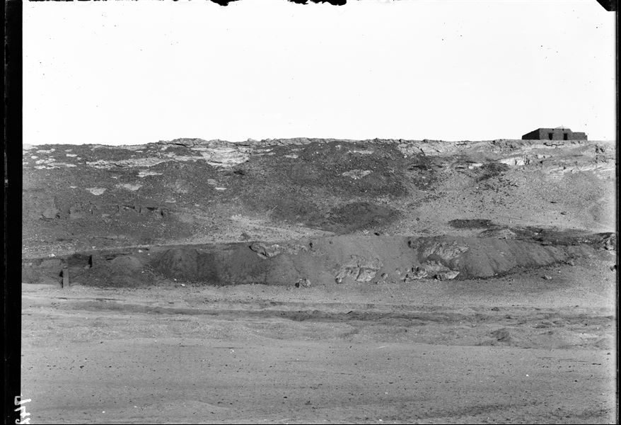 View of the hill with the tomb of the holy man Sheikh Musa. On the left, a small part of the impressive mud-brick structures that formed a vast fortified area, defending the northern part of the country. Schiaparelli excavations. 