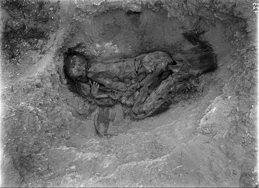 Scattered burials in the desert area north of the northern hill. The discovery of this burial must have been of great interest to Giovanni Marro, the anthropologist on the mission, as this find is documented in five different images. It is a basket burial in a contracted position. The individual is wrapped in cloth, and has their right index finger positioned near their face. Farina excavations. 