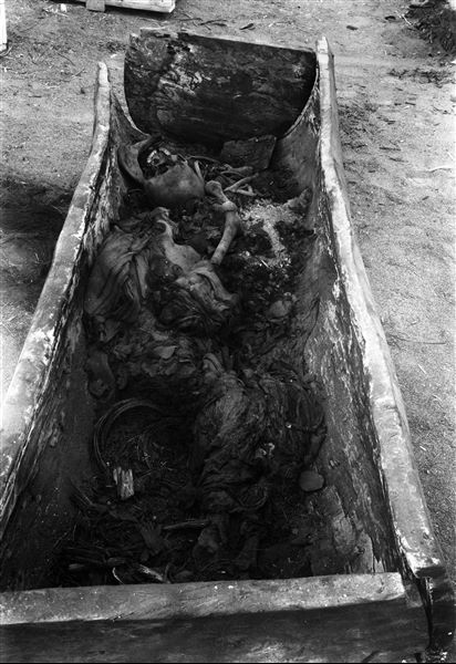 Disturbed burial lying on its side, in a tree-trunk coffin of fine wood. Inside the coffin are the remains of some baskets. Schiaparelli excavations. 