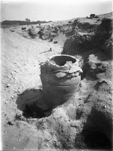Scattered burials on the eastern slopes of the northern hill.  A large terracotta burial vase consisting of several stacked circular ceramic pieces. Around it there are traces of small burial pits with vegetal remains of mats. Farina excavations. 