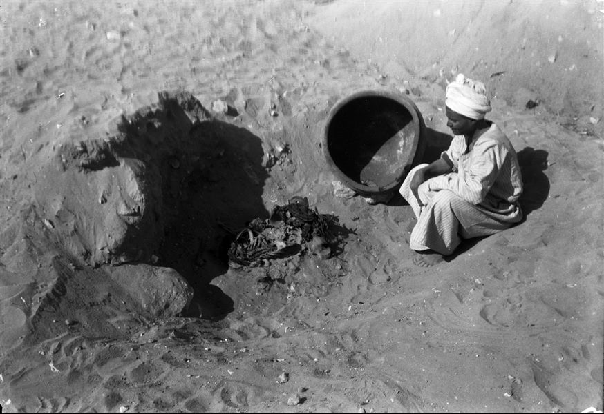 Scattered burials on the eastern slopes of the north hill. Skeletal remains laid under an overturned vase. The presence of a young worker was to illustrate the considerable size of the vase. Schiaparelli excavations. 