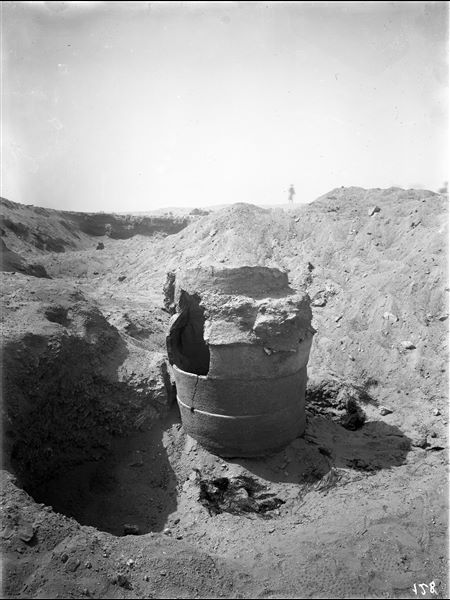 Scattered burials on the eastern slopes of the northern hill.  A large terracotta burial vase consisting of several stacked circular ceramic pieces. The large crack on its side indicates previous interference with the vessel. Around it are the remains of pit burials. Farina excavations. 