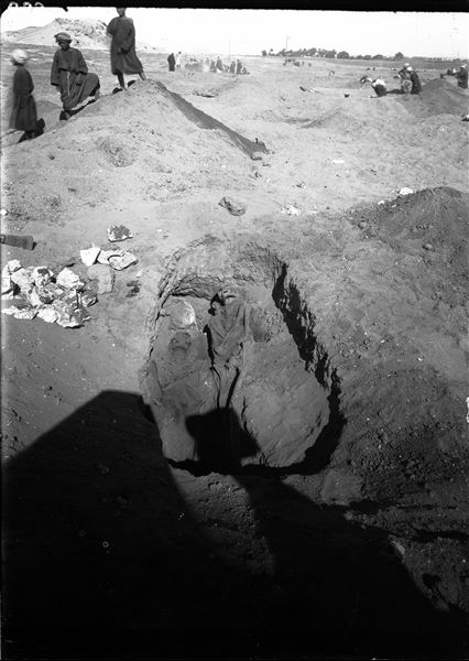 Burials in the plain to the east of the northern hill. In the foreground, a grave with two deceased individuals lying down. In the background, the modern village of Abu Hummas. Schiaparelli excavations. 