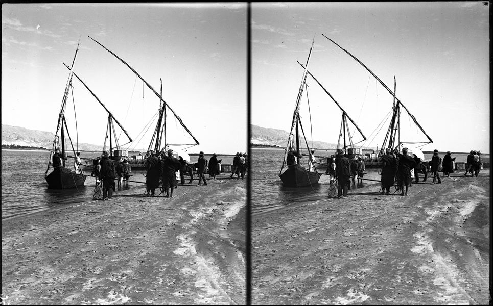 The transport by land ended on the banks of the river where the materials were loaded onto sturdy feluccas (a type of Egyptian sailboat) to be transferred to the warehouses which, for Gebelein, were at the Franciscan Missionary Station in Luxor. The picture shows some of the crates marked M.A.I. (Italian Archaeological MIssion) with their relevant sequential numbers. In the centre of the picture, under a parasol, Ernesto Schiaparelli can be seen followed by Giovanni Marro. Schiaparelli excavations. 