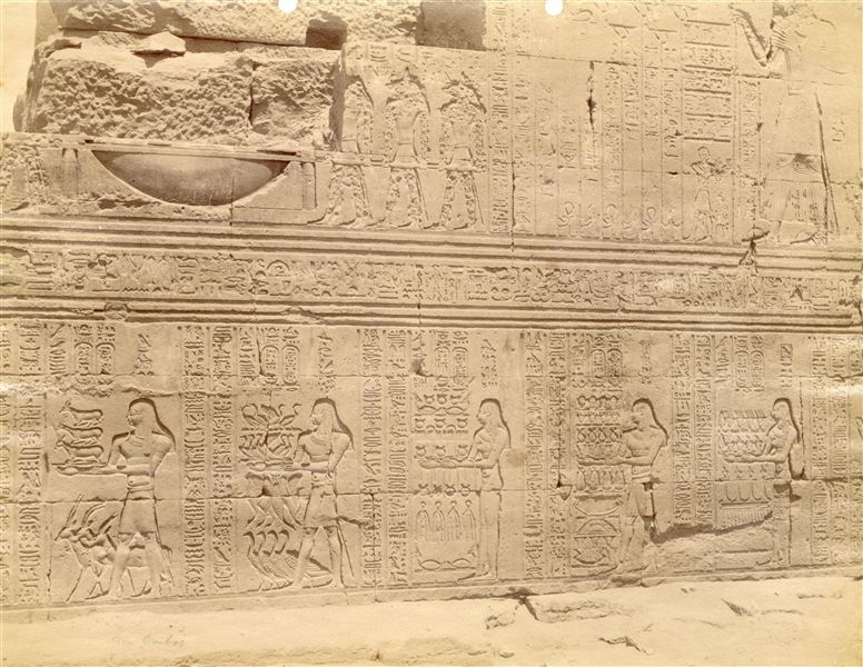 L'immagine mostra una parte dei testi e delle scene che decorano la parete esterna dell'atrio colonnato (ipostilo) del tempio di Sobek e Haroeris a Kom Ombo.  
