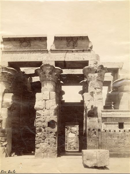 The photograph offers a glimpse into the interior of the hypostyle hall of the Temple of Sobek and Haroeris at Kom Ombo, seen frontally from the entrance to the sanctuary. 