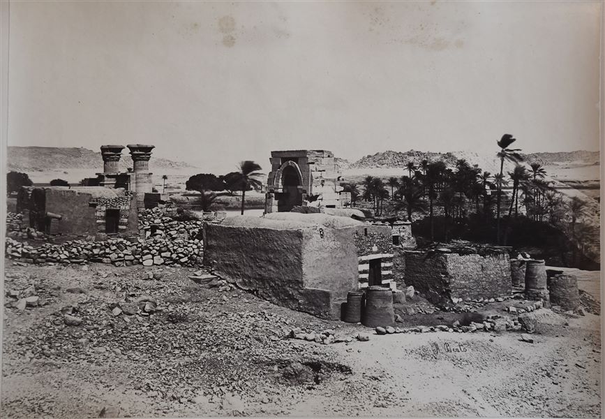 The remains of a temple, with two columns and a doorway, formerly erected on the island of Bigeh, a small island near that of the island of Philae. Among the remains of the temple, mud-brick structures from modern times are visible. Today, the small island is partially submerged by Lake Nasser. 