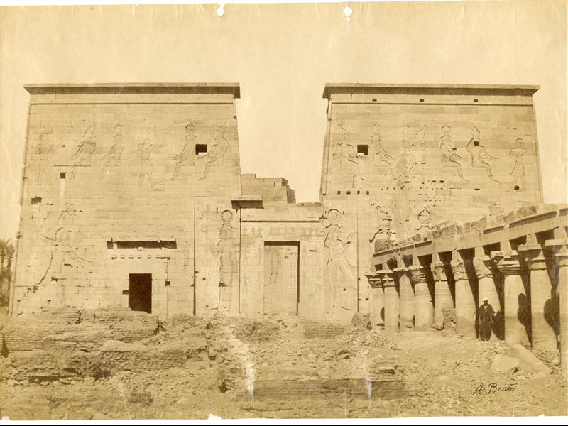 The photograph shows the pylon of the Temple of Isis on the island of Philae (shown in its entirety) with the colonnade on the right. The author's signature is visible at the bottom right. 