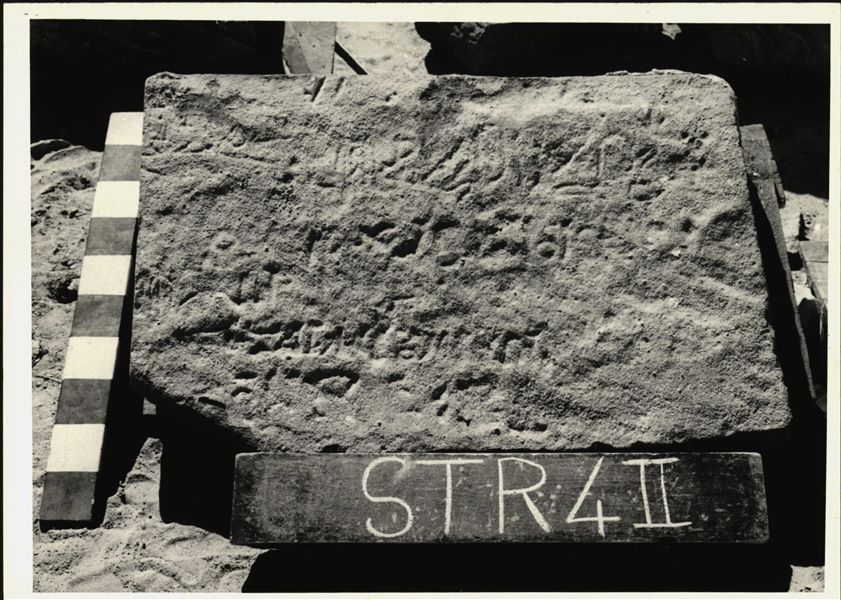 Storage at Wadi es-Sebua, one of the 66 blocks from the rock-cut chapel of Ellesiya stored waiting to be transported to Turin, after the United Arab Republic decided to gift the rock-cut chapel to the Italian Republic. One of the blocks forming part of the right side of the recess, on the rock-cut chapel's exterior façade.