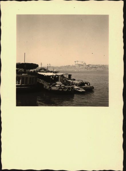 Photograph taken in the area of the site of Ellesiya, when Lake Nasser had already formed and was full. In the foreground, there are three boats for the transport and accommodation of the people who were working on the rock-cut chapel of Ellesiya. In the background, there is a construction site in action. 